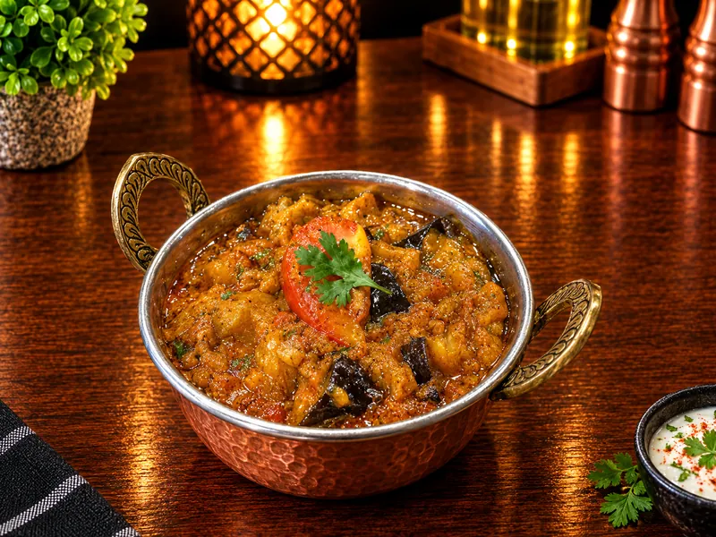 Aubergines Bhaji : aubergines sautées aux épices et tomate, servies dans un bol en cuivre