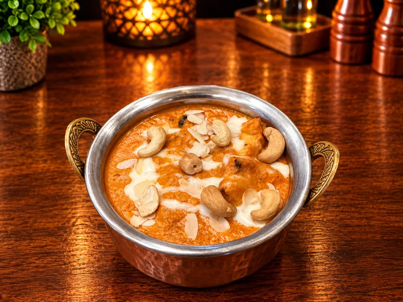 Badam Passanda : curry crémeux aux amandes et noix de cajou, servi dans un bol en cuivre