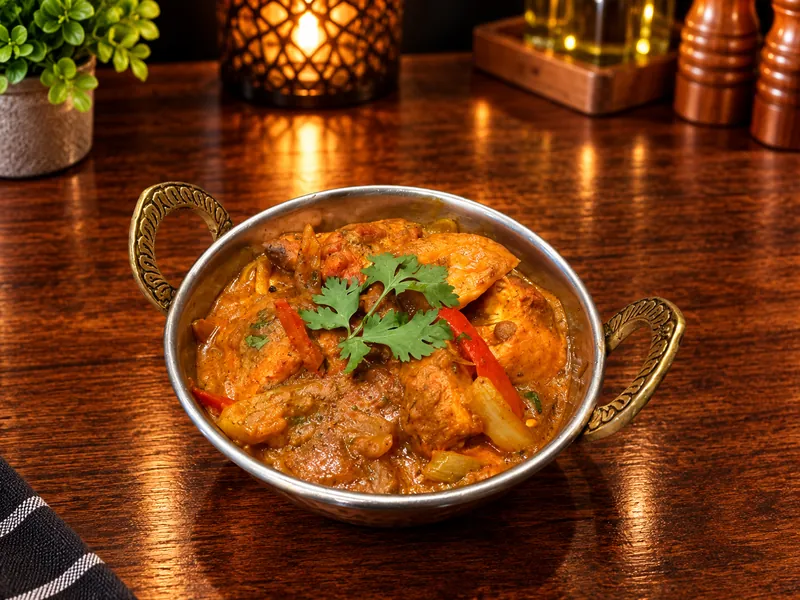 Jalfrezi : curry aux poivrons et oignons, servi dans un bol en cuivre